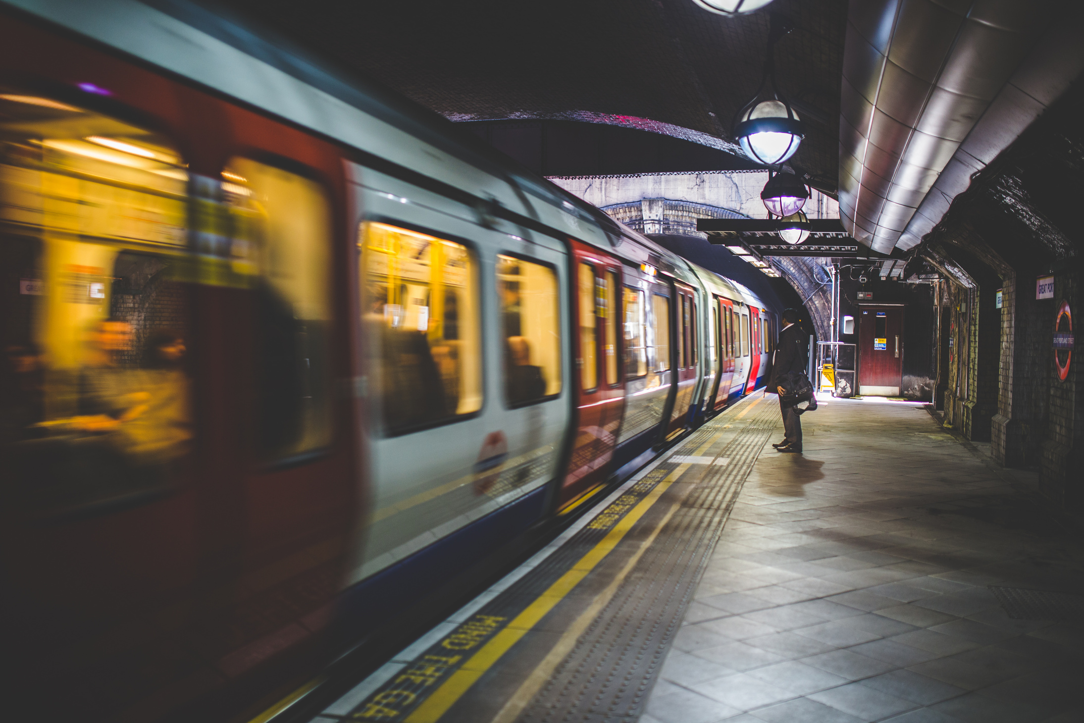 Man Standing Beside White and Red Train